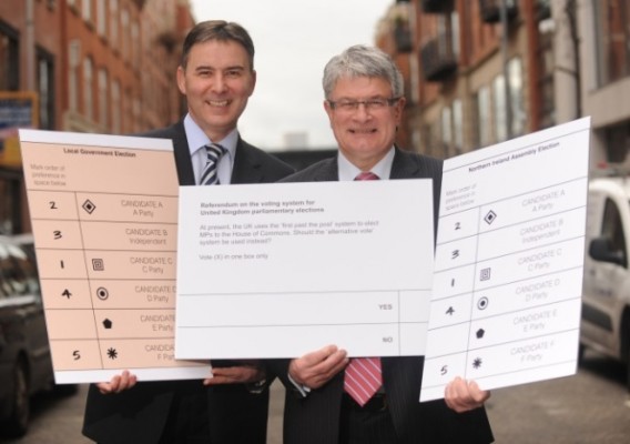 Chief electoral officer Graham Shields and head of the Electoral Commission in NI Séamus Magee posing with enormous ballot papers