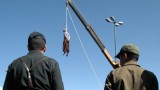 Iranian soldiers watch a man being hanged in Shiraz, south of Tehran © AFP/Getty Images