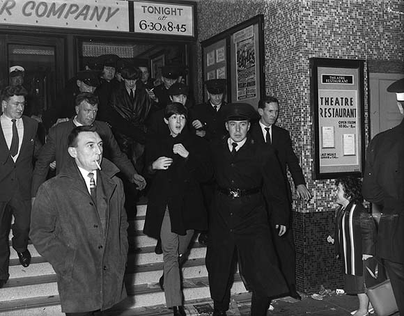 The Beatles, flanked by RUC officers, on their way to their second and final Belfast concert, at the Ritz cinema, 8 November 1964