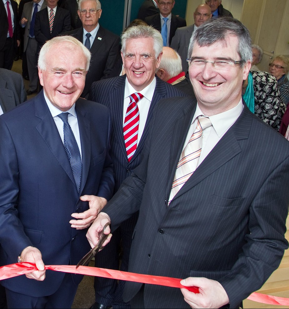 Tom Eliott wielding scissors at the opening of David McNarry's Saintfield Advice Centre Opening