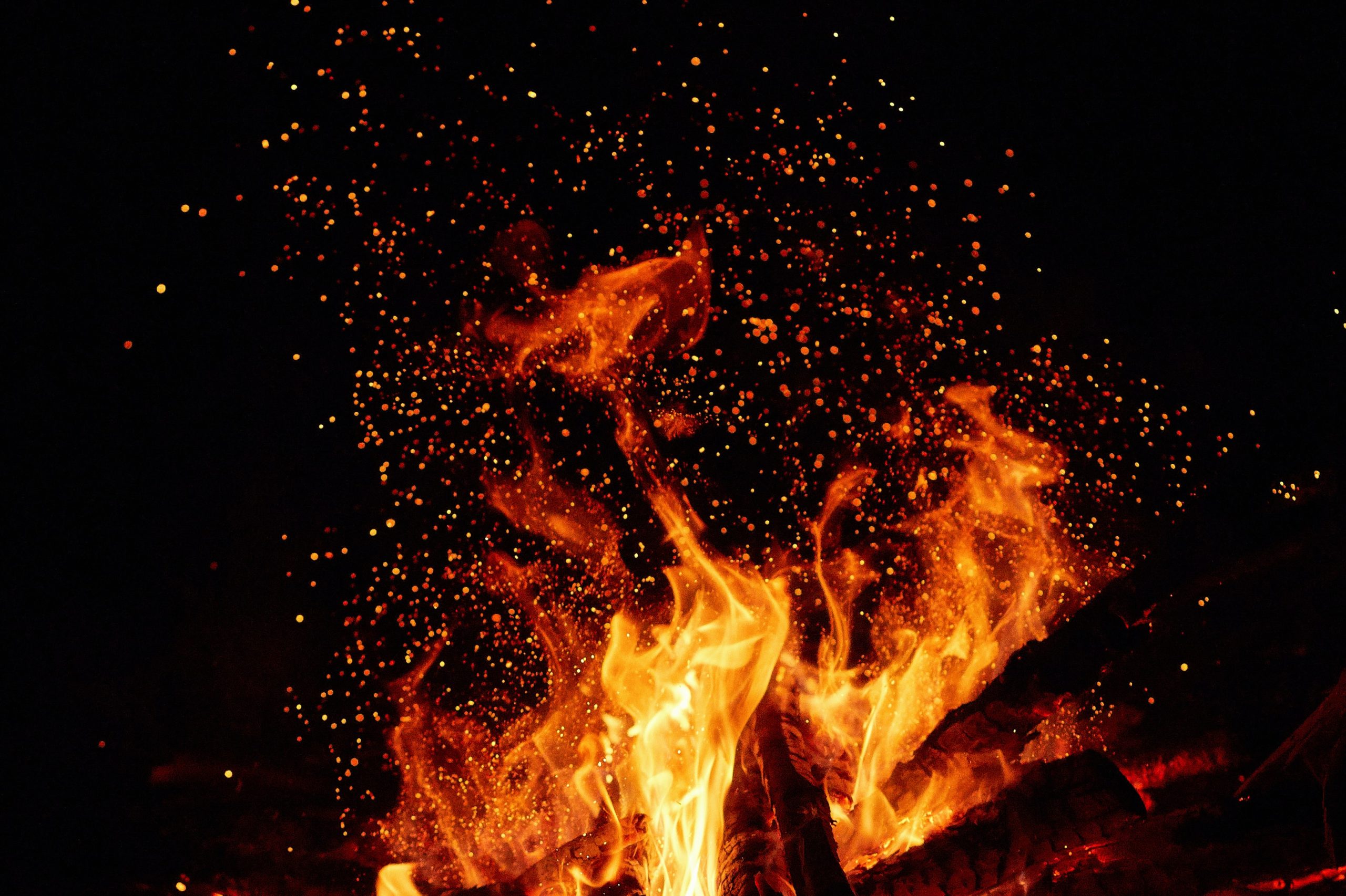 Night photo of a bonfire with sparks. Bright flame against a dark background. High resolution photo of a bonfire.