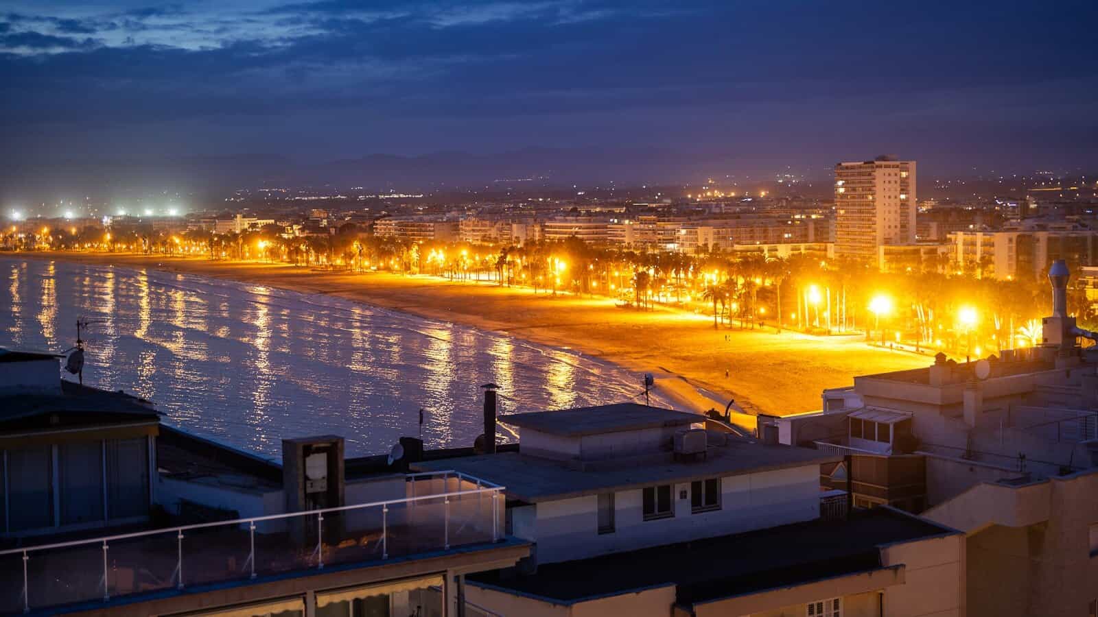 A night view of a beach and a city