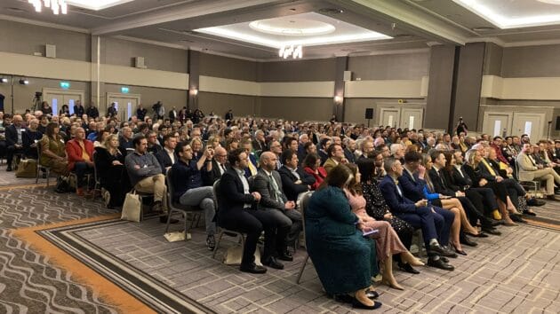 Full conference hall with people seated during Andy Burnham's speech to the Alliance Party