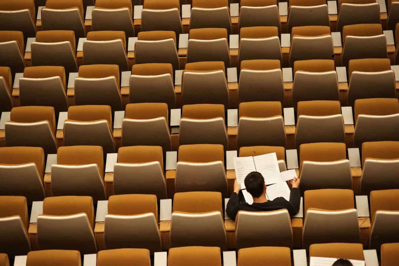 person reading in empty lecture hall
